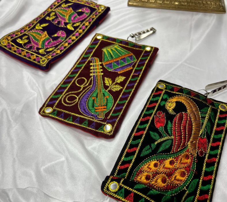 Product listing_Indian Accessories _IMG_3899 (1) Three embroidered wallets sitting on a table.
