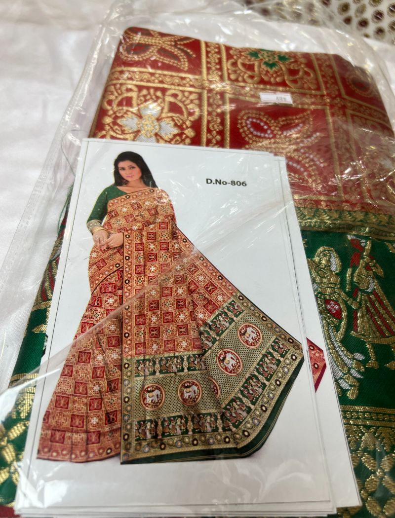 A woman in an indian sari is sitting on the floor.