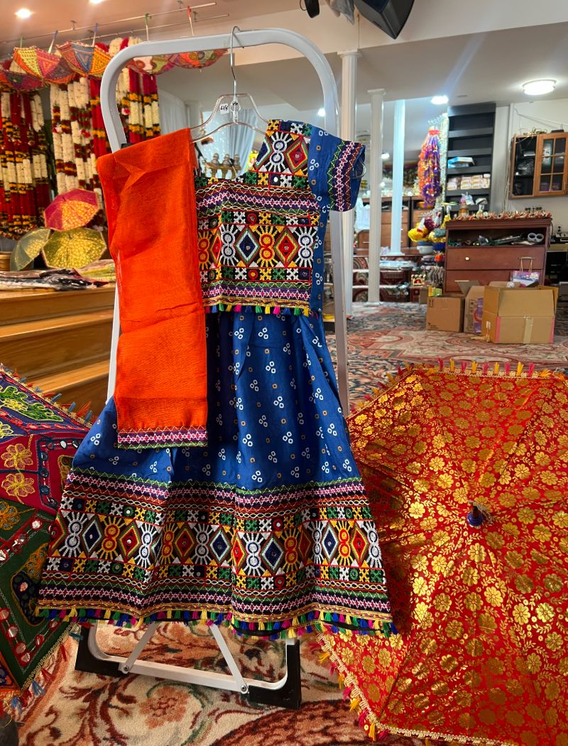 A blue dress and an orange umbrella on display.