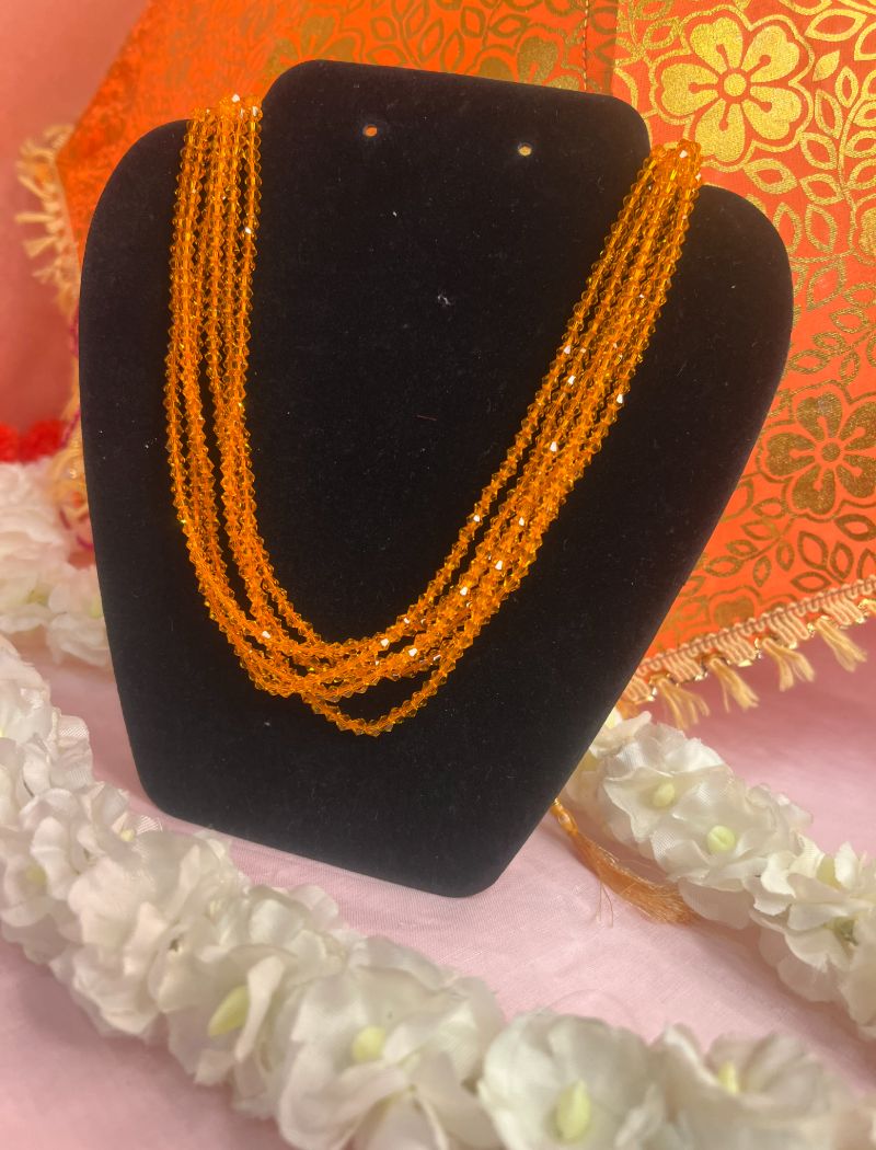 A black necklace with orange beads on it