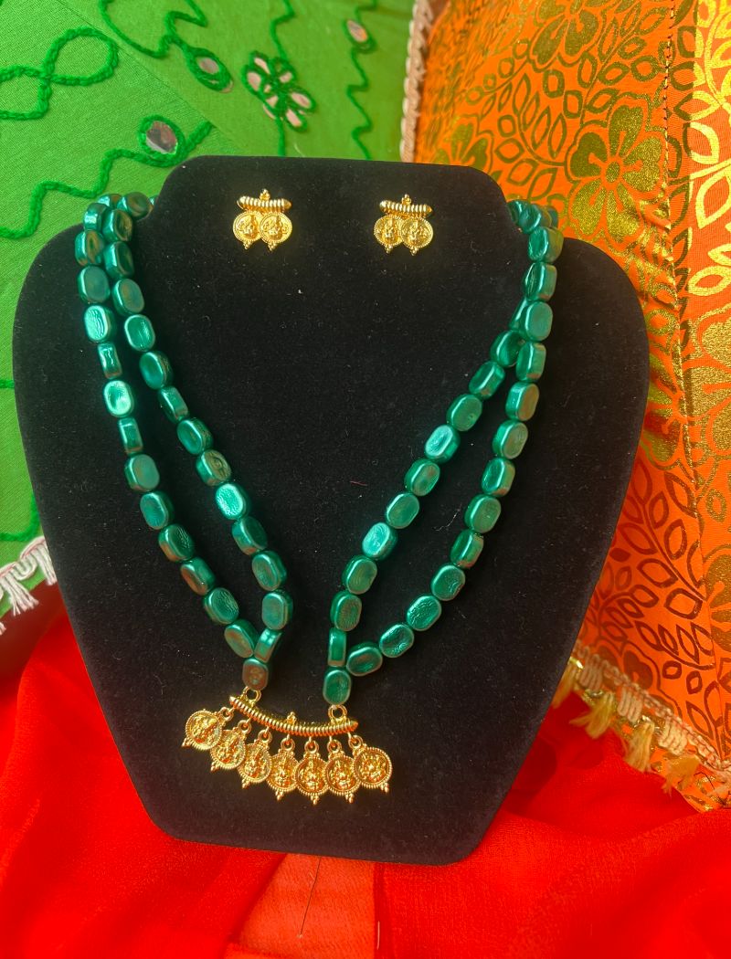 A necklace and earrings set with green beads.