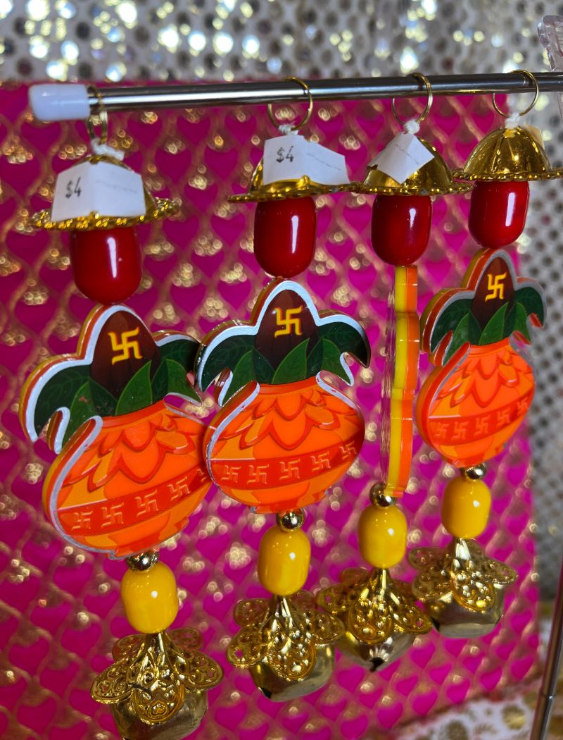 A group of four orange and yellow ornaments hanging from strings.