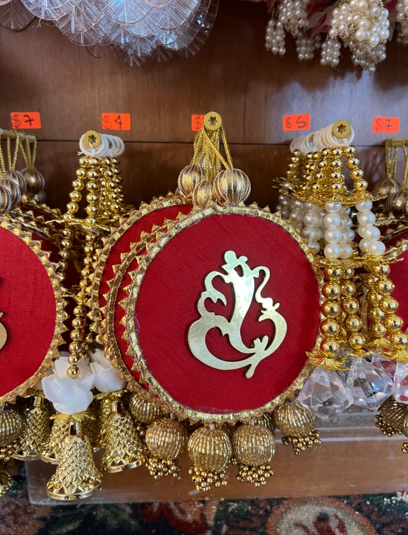 A row of red and gold decorations with the ganesh symbol.