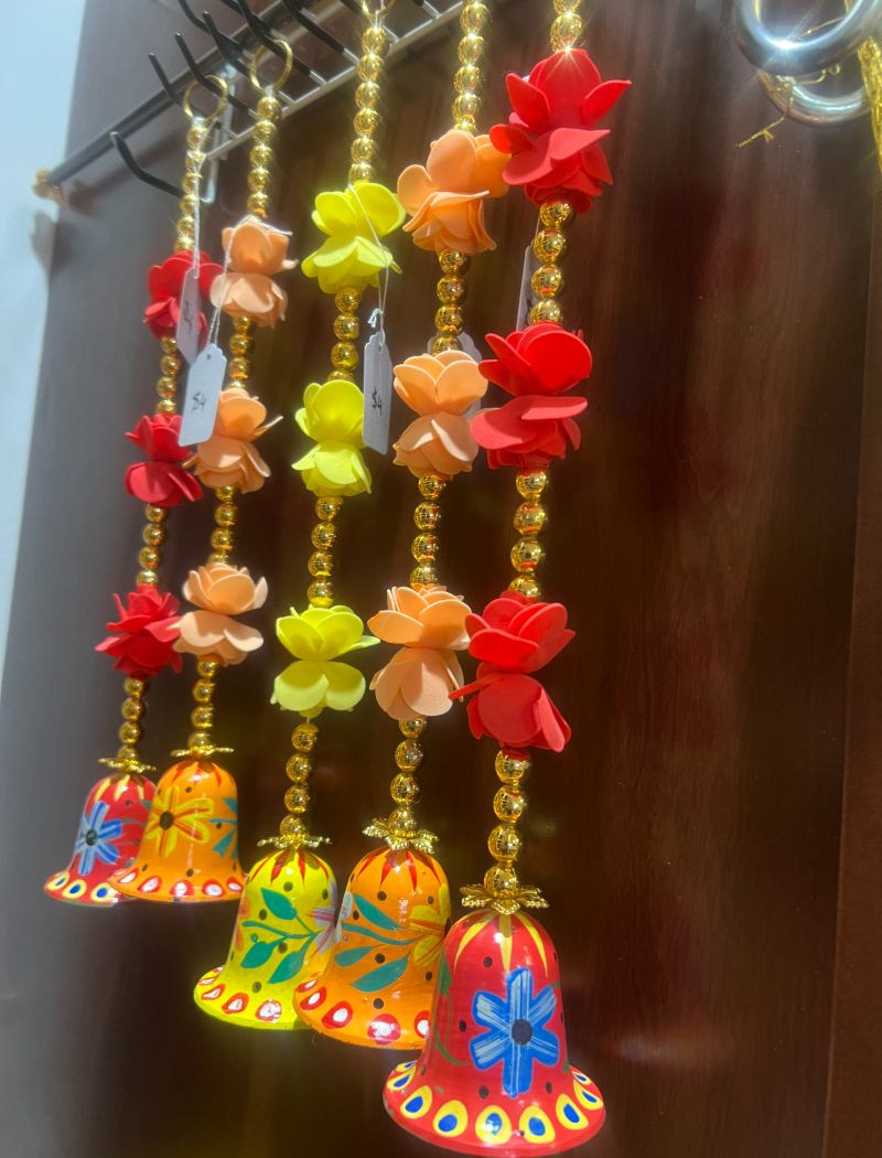 A close up of some colorful bells hanging on the wall