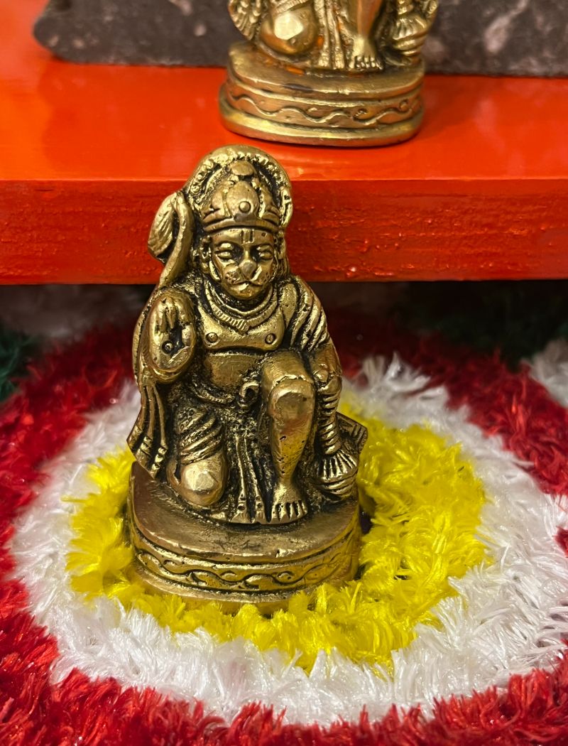 A small statue of hanuman sitting on top of a flower.