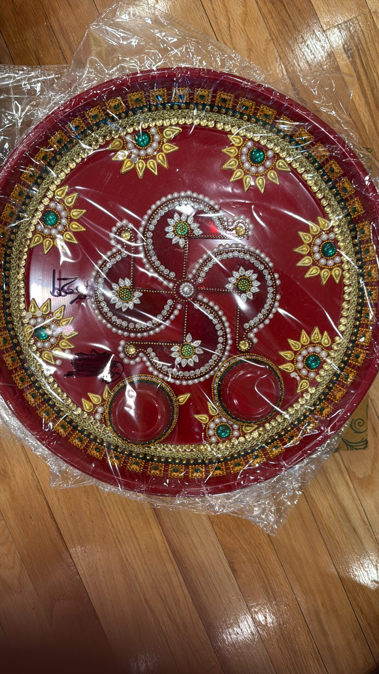 A red plate with gold and green designs on it.