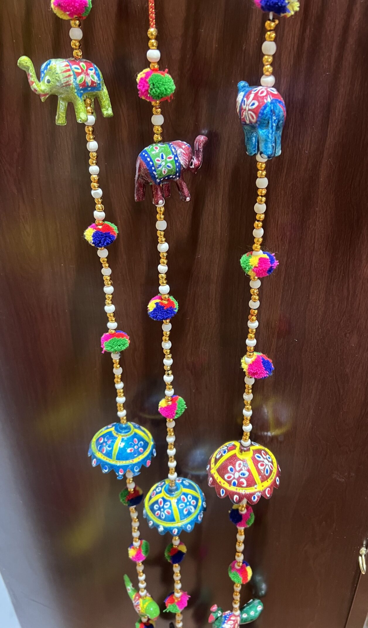 A string of beads with elephants and bells hanging from it.