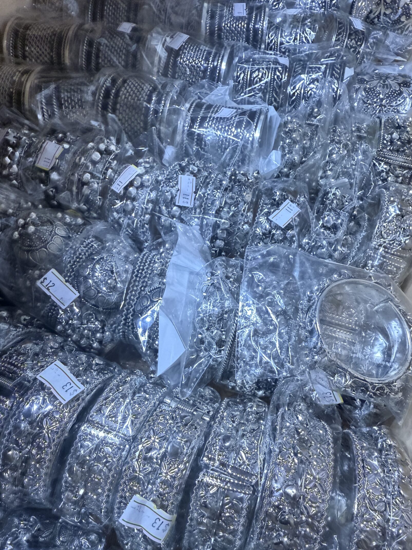 A pile of silver jewelry sitting in the middle of a room.