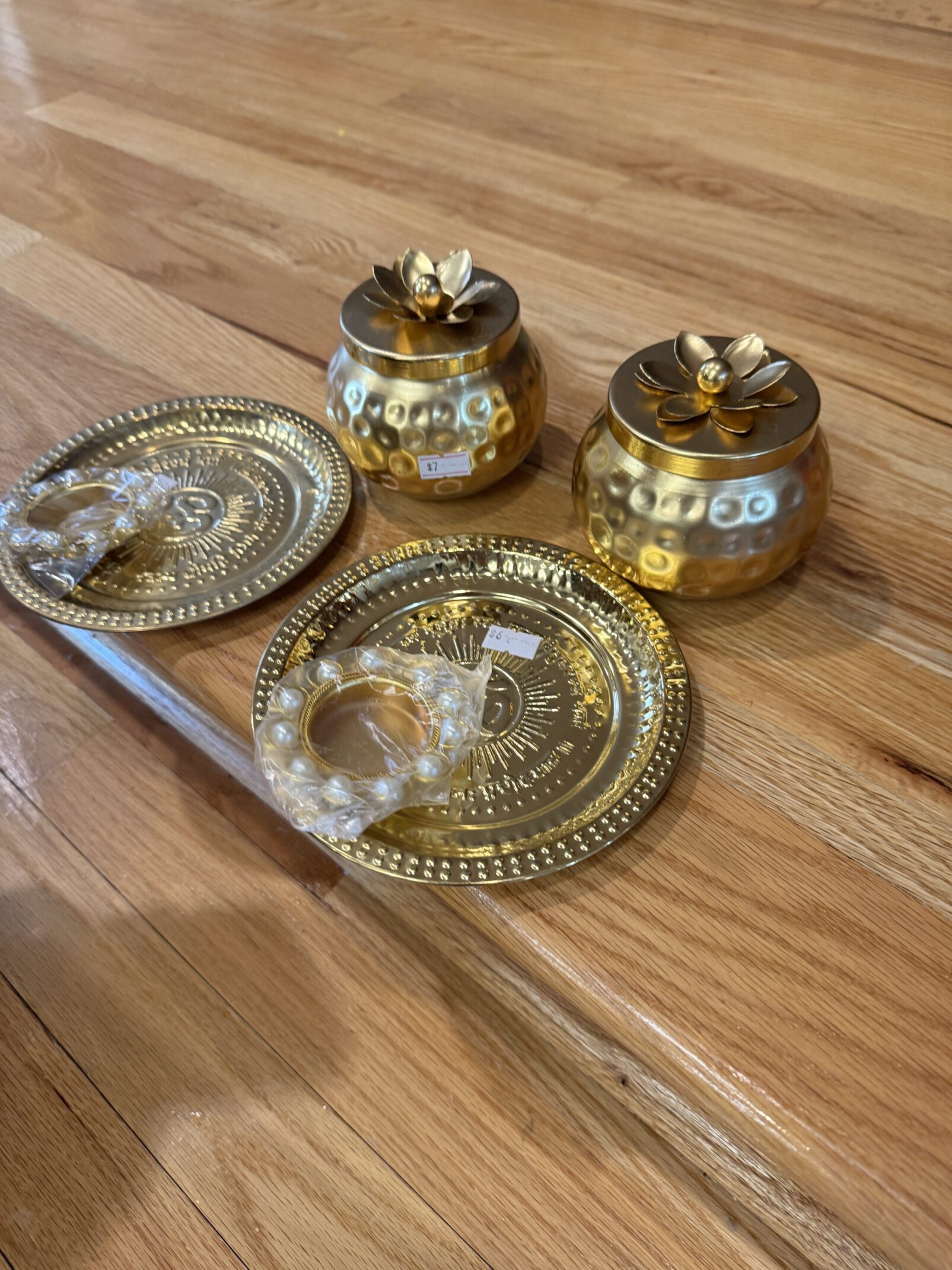 A wooden table with two gold plates and a candle holder.