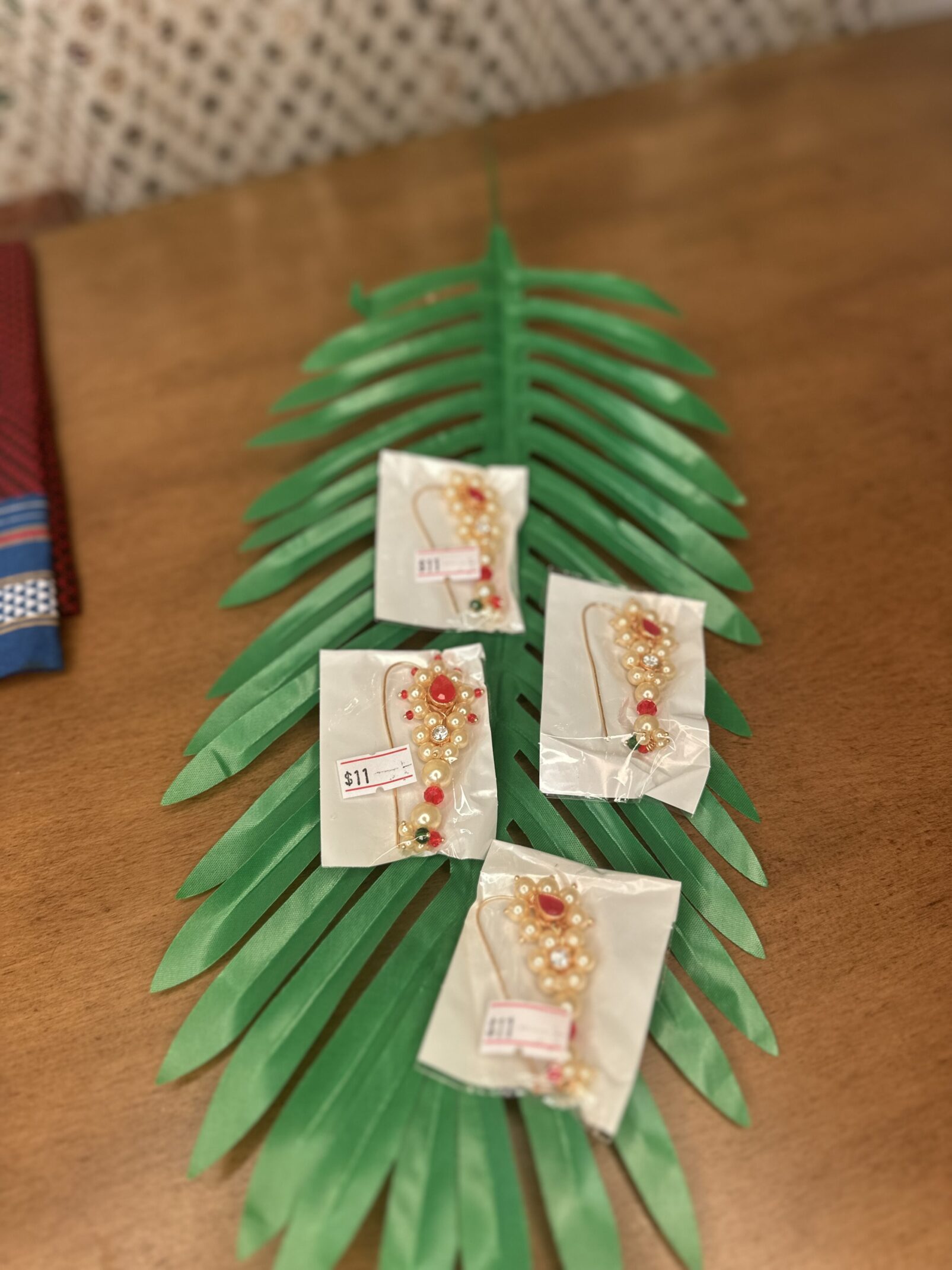 A table with palm leaves and four cards on it.