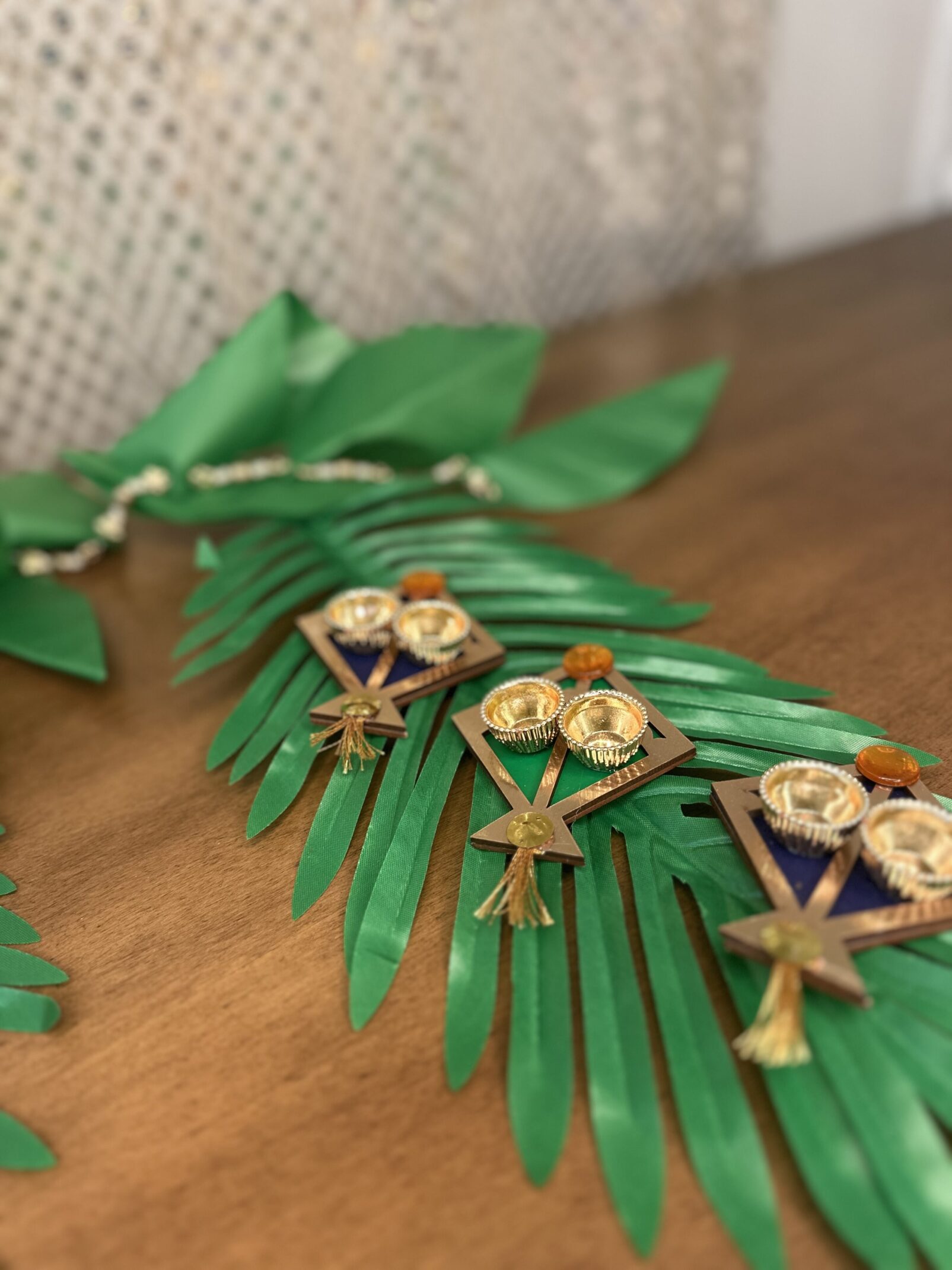 A wooden table with green leaves and some gold decorations