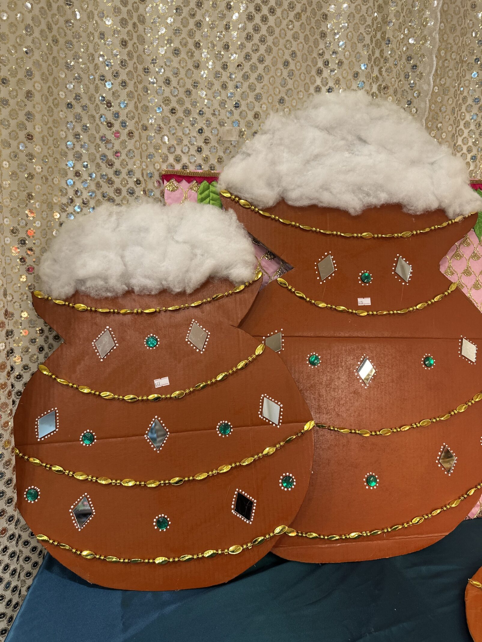Two brown pots with white fluffy tops on a table.