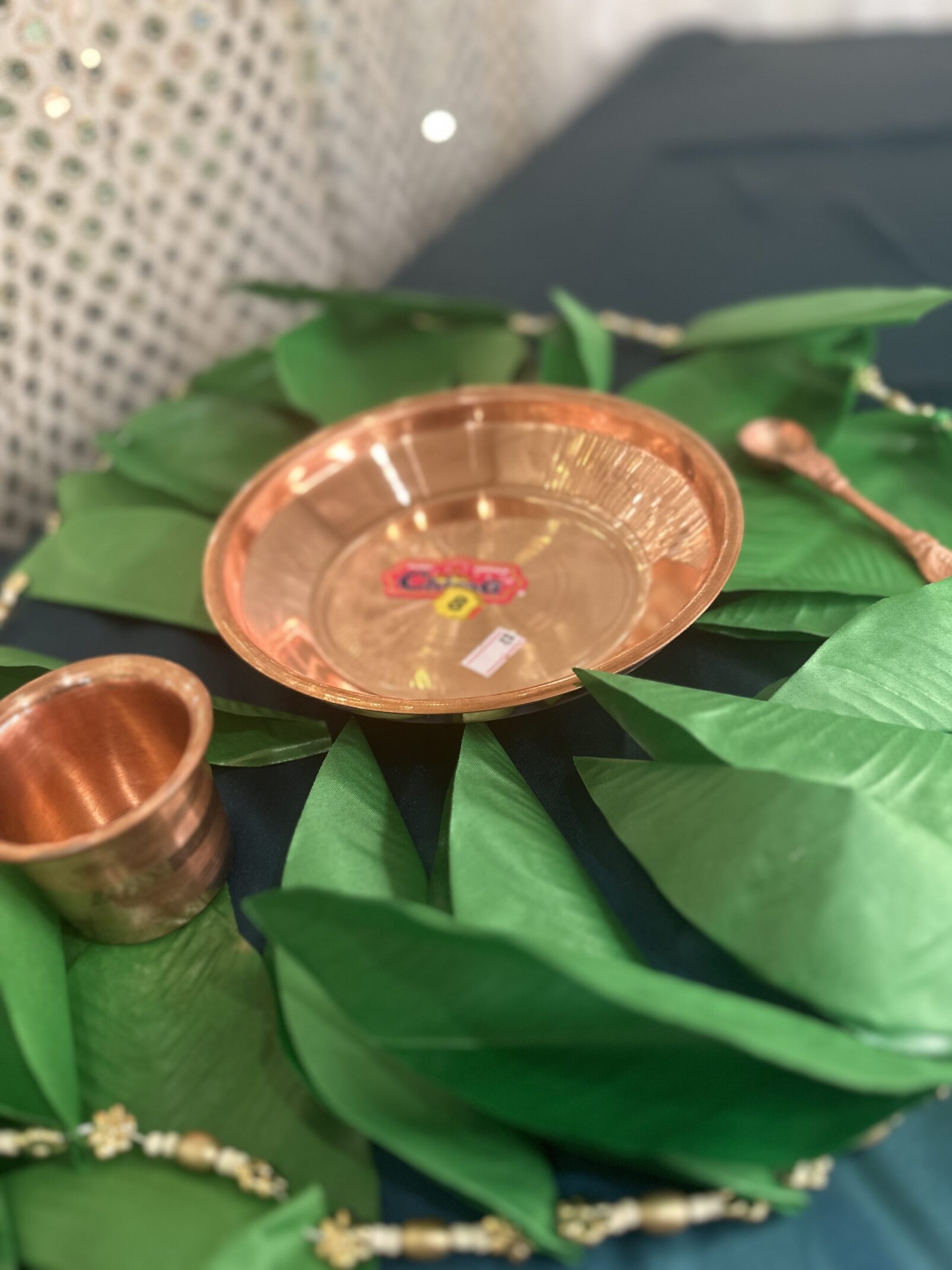 A bowl and cup on top of green leaves.